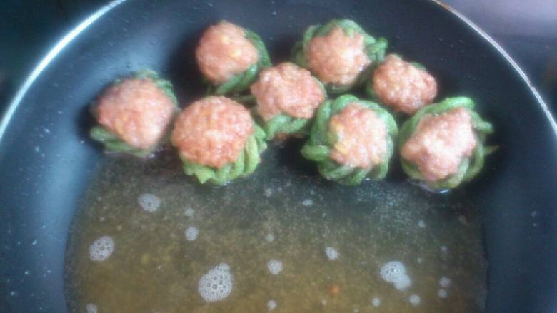 津味儿豆角焖肉丸,豆角肉丸入热油锅,中小火煸至肉丸表面发黄,淋去多余油