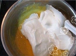 酥皮蛋糕卷,分三次将打好的蛋白加入到蛋黄液里去,由上至下小心翻拌搅匀。