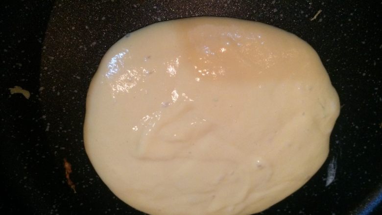 美式培根煎蛋热香饼pancakes,平底锅开小火热下锅,锅子有温度之后,开始下面糊;每次可以用勺子乘取固定的面糊量,面糊以打圈的方式入锅,可以形成一个圆;面糊开始起大泡的时候翻