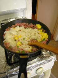 三色蛋炒饭,把<a style='color:red;display:inline-block;' href='/shicai/ 6501'>剩米饭</a>倒入锅中,用铲子捣碎,翻炒