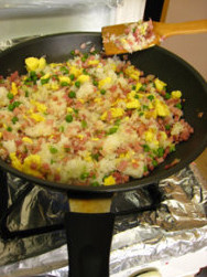 三色蛋炒饭,加入少许清水,把米饭尽可能炒散,加入盐调味,翻炒均匀,出锅