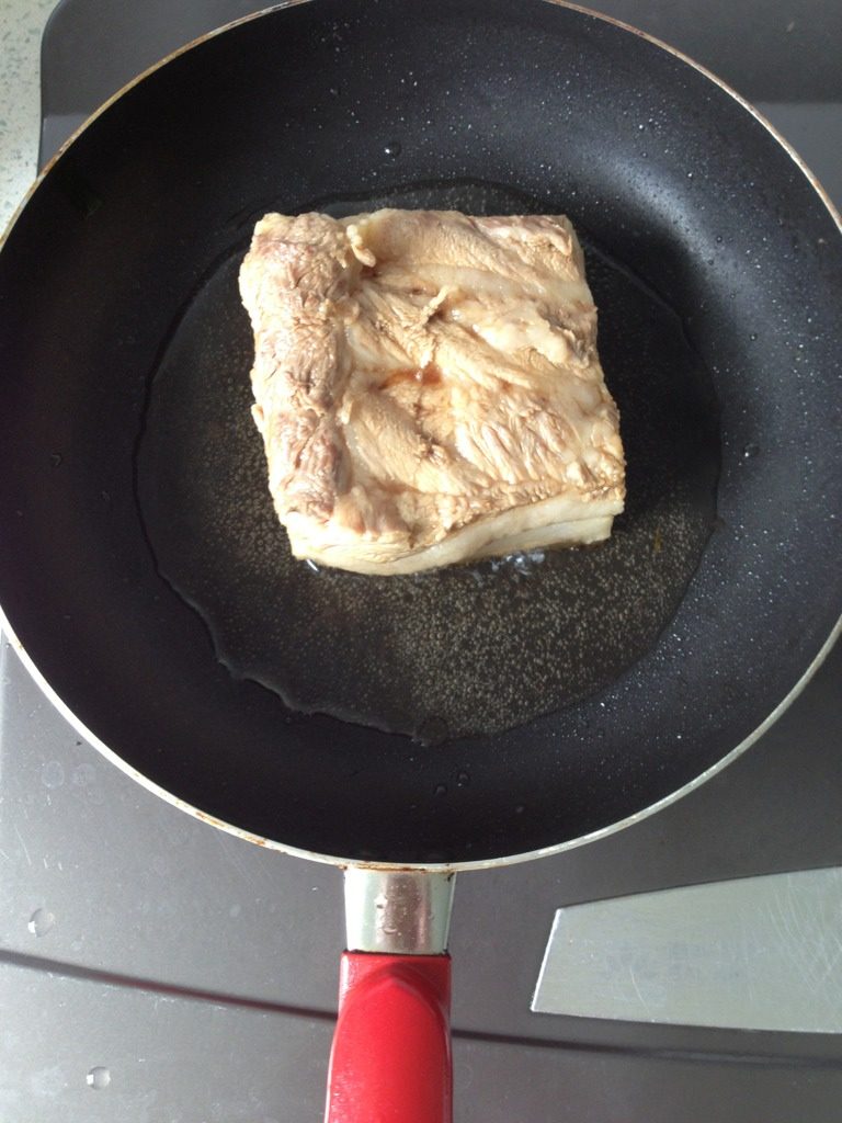 香芋梅莱扣肉,锅肉加少许油,将抹匀老抽后的五花肉放入锅内,盖上锅盖,炸至猪皮呈金黄色