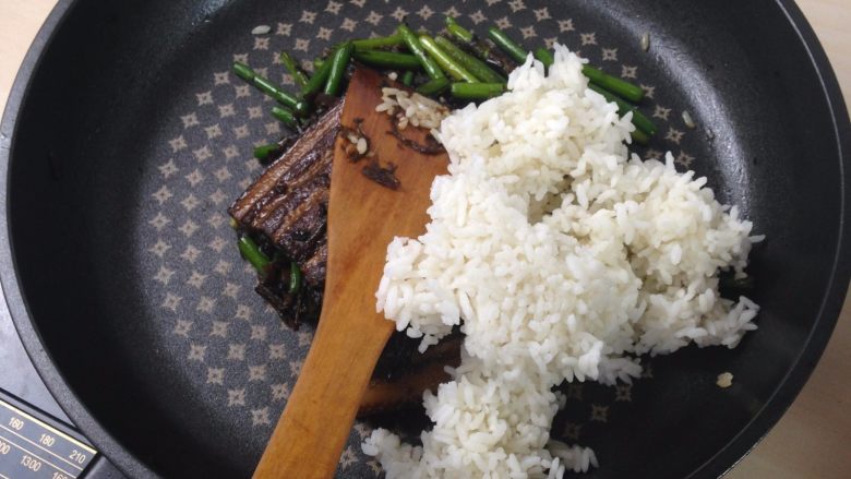 梅干菜蒜苔炒肉,倒入米饭炒至上色均匀