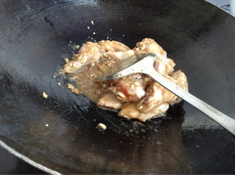 蒜香鸡翅,等油热以后把鸡翅全倒进去翻炒。翻炒到六七成熟。
