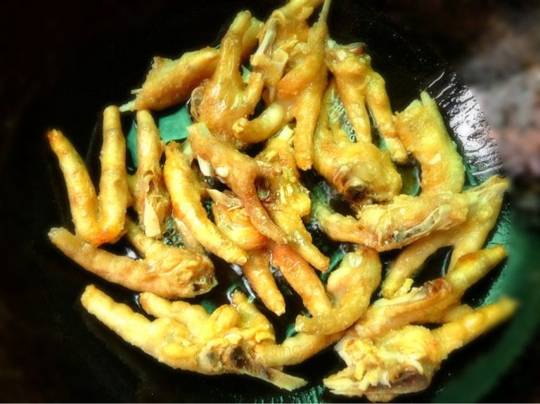 虎皮凤爪,如图锅里放油烧至六成热时放入鸡爪中小火稍炸一会幌动一下锅，关火等锅内油不响时再翻炸另一面，炸至金黄即可别太焦（放入鸡爪立即盖锅盖，稍微留点缝隙，不然锅都能震动，哈哈所以一定要小心点哦，溅油到手上更疼）