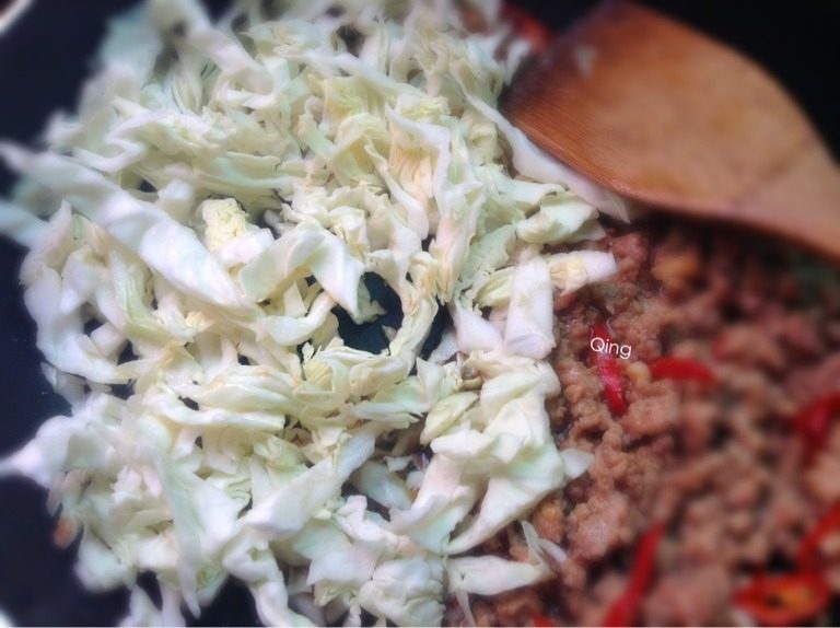 肉末粉条,如图再将炒好的肉放置一旁，下包菜翻炒至软