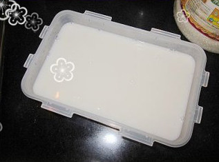 微波杏仁豆腐,将奶液倒在一个方形容器里,等冷却后放入冰箱