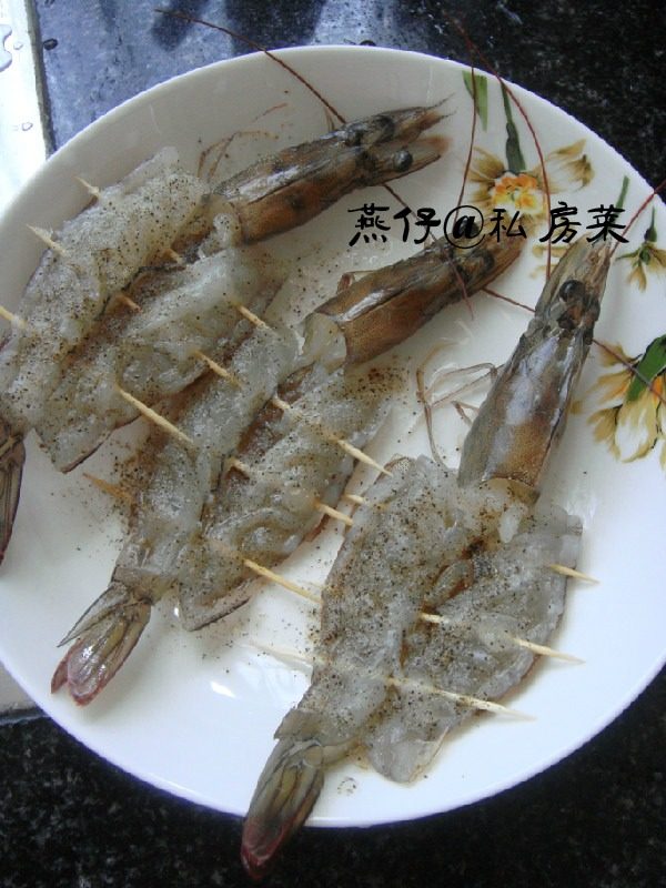 香煎黑椒大虾,如图在虾背的地方切开，去掉虾线，洗净。用牙签穿过，加入盐，<a style='color:red;display:inline-block;' href='/shicai/ 717'>味精</a>，<a style='color:red;display:inline-block;' href='/shicai/ 13418'>红酒</a>，<a style='color:red;display:inline-block;' href='/shicai/ 134340'>黑胡椒粉</a>稍稍腌制15分钟。