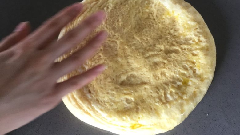 冬阴功鸡腿培根披萨,在桌面上抹油,把发酵好的面团放在桌面上轻轻按平,整出比9寸略大的饼底