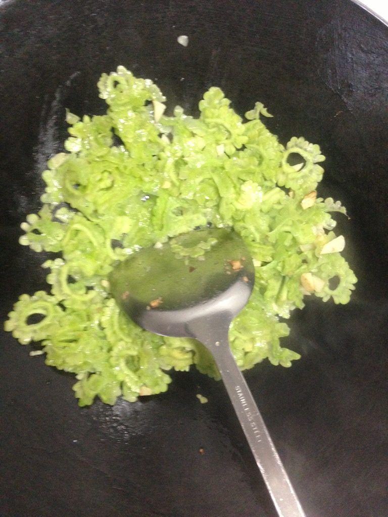 肉沫苦瓜,如图锅内下少许油,小火爆香蒜,改大火洒少许水翻炒苦瓜至变色。