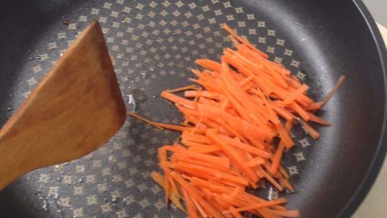 泡菜肥牛石锅拌饭,放入胡萝卜丝翻炒片刻