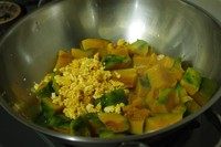 咸蛋焗南瓜（全蛋版）,放入南瓜，再放上咸蛋碎，翻炒到南瓜和咸蛋混合在一起就好