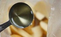 烤薯角,装入食品袋。然后倒入一大勺食用油。(看着一大勺实际炒菜都不够)