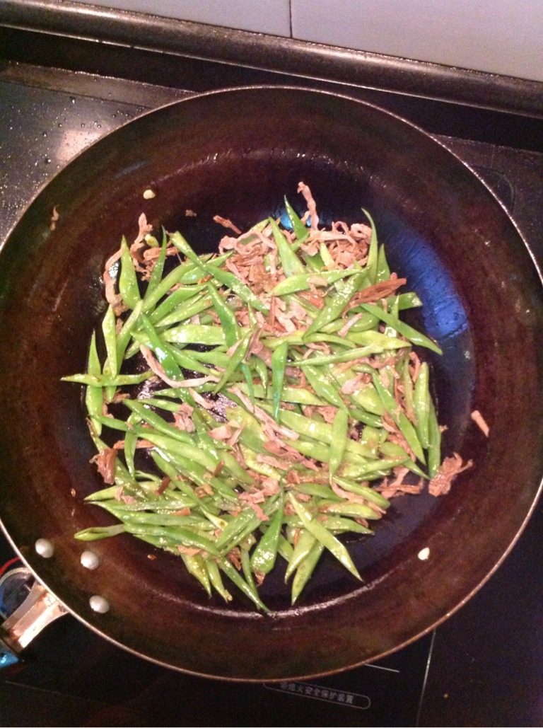 笋干菜炒豆角,锅中放油,八成油温时,倒入焯好的豆角丝煸炒,再放入泡好的笋干菜煸炒,放少许水盖上锅盖煮2分钟。