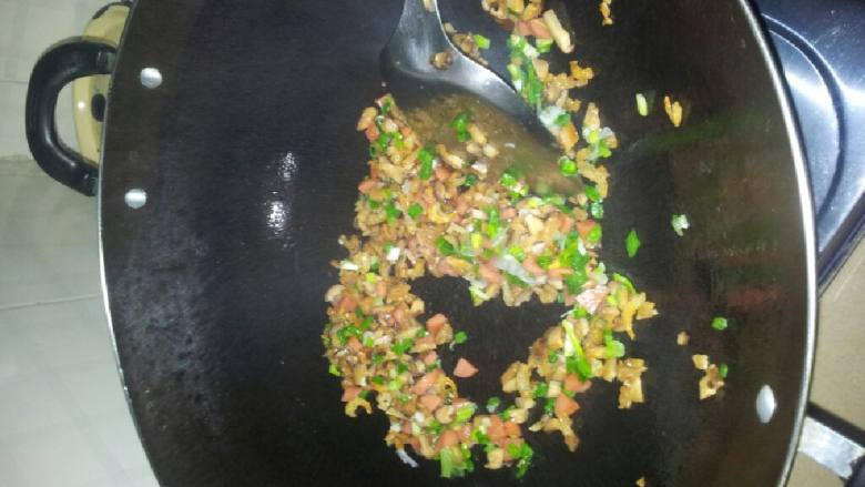 香菇火腿炒饭,锅内放油，油热后下材料翻炒，加少许盐，炒至材料略熟