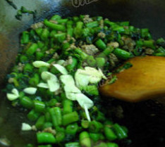 橄榄菜肉沫四季豆,加入炒好的肉馅,蒜片,翻炒出锅
