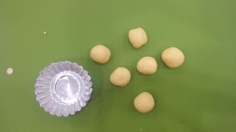 港式蛋挞,冷藏后的蛋挞皮分成大小均匀的小面团,分别放入蛋挞模中,用大拇指按压成贴合模子的薄片状