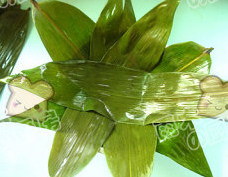 粽香糯米排骨,取一深底盆,将粽叶铺在盆底,一片压在一片上,大约5片就铺满了