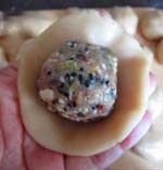 京式提浆五仁月饼,取一份饼皮,拍成小圆饼,包入一份馅