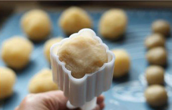 广式椰蓉月饼,直到把椰蓉完全包裹住,用手搓成略小于月饼模内径的圆柱体,在面团表面拍上少许面粉,将圆柱形面团放进月饼模内