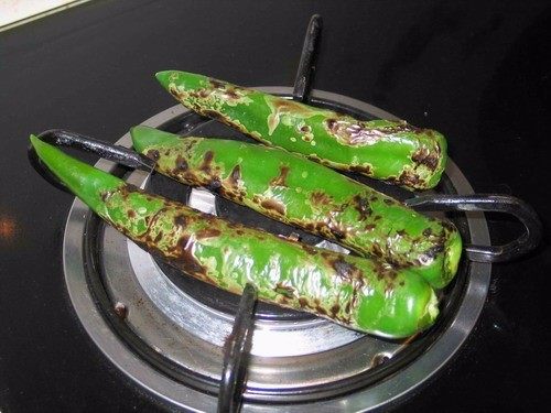 芝士烤甜红薯,烤青辣椒,用铁叉串着青辣椒,在燃气灶上烤4到5分钟。期间不时转动,烤好的辣椒放到一个碗,盖上保鲜膜,晾凉。剥去烧焦的皮去掉茎和种子。切碎备用