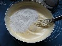三色慕斯杯子蛋糕,低筋粉分两次筛入盆中,用手动打蛋器从两点钟方向切入,一边轻轻转动从九点钟出。左手逆时针慢慢转动面糊盆。