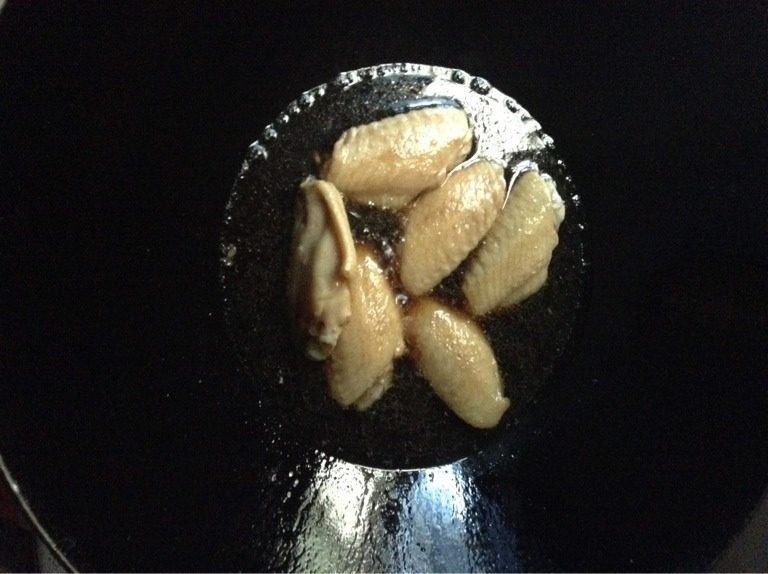 可乐鸡翅,锅烧热时倒入姜片,翻炒几下捞出,倒入鸡翅,煎至鸡翅两面呈金黄色(小心别焦咯)一定要小火煎哦!