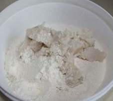 苏式栗子莲蓉月饼,油酥中的面粉和猪油放入容器中,手上带上一次性手套或者套上保鲜袋抓匀