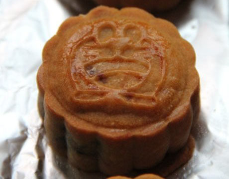 广式紫薯坚果月饼,预热烤箱,在月饼表面喷上一些水,放入烤箱170度,中层,烤8分钟定型后取出来刷蛋黄水,再放入烤箱,烤12分钟,直到表面金黄。