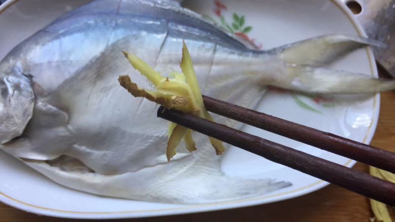 清蒸鲳鱼,将鱼放入盘中,加入姜丝
