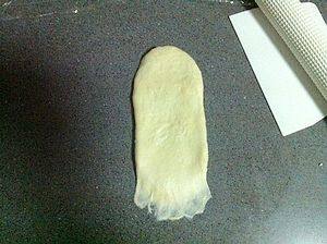 奶香芝麻卷,翻面,将也面的一边压薄