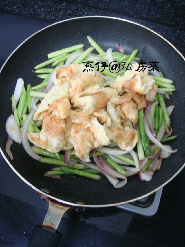 芦笋洋葱炒鸡蛋,如图锅里再次倒入一点油，把洋葱和芦笋下锅翻炒，加入盐，继续翻炒到差不多熟了，再倒入鸡蛋，味精，稍稍翻炒，即可出锅。