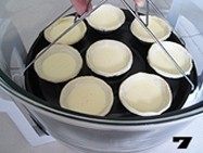 美味蛋挞速成法--【椰丝蛋挞】, 用取物夹夹紧烤盘,平稳的放置在锅内。
