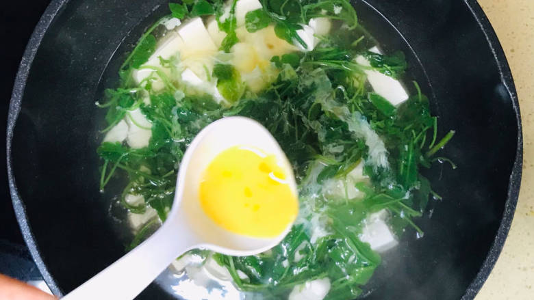 豆腐蛋花汤,将鸡蛋液一勺一勺淋上去,不要搅拌,继续煮沸
