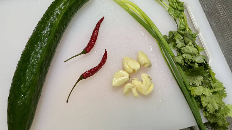 凉拌粉丝黄瓜,黄瓜搓洗干净,小米辣洗净,蒜剥皮洗净,小葱香菜择好洗净