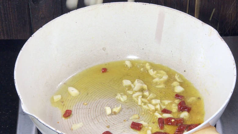 酸辣菜苔,起锅热油,放入蒜末和干辣椒炒香