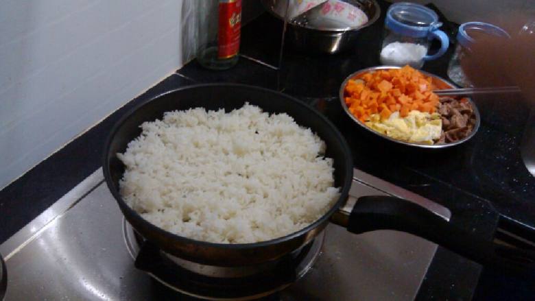 洋葱肥牛炒饭,将白饭倒进平铺平底锅,翻炒至饭变干身后,加入适量盐、糖、鸡粉、酱油
