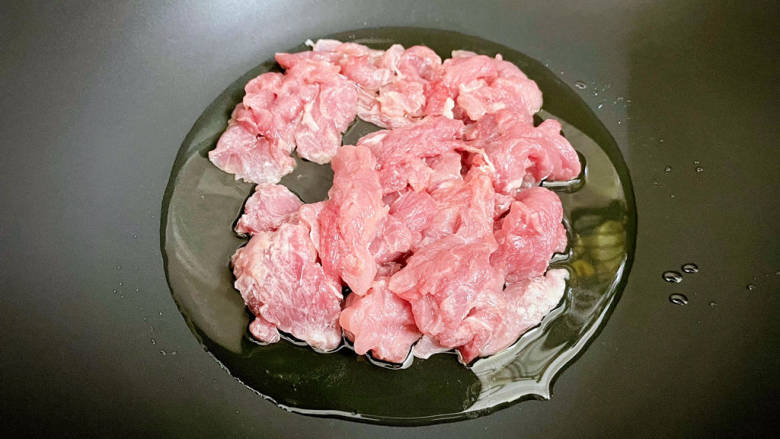 丝瓜肉片,锅中倒入适量的食用油烧热，放入猪肉，翻炒至变色变白