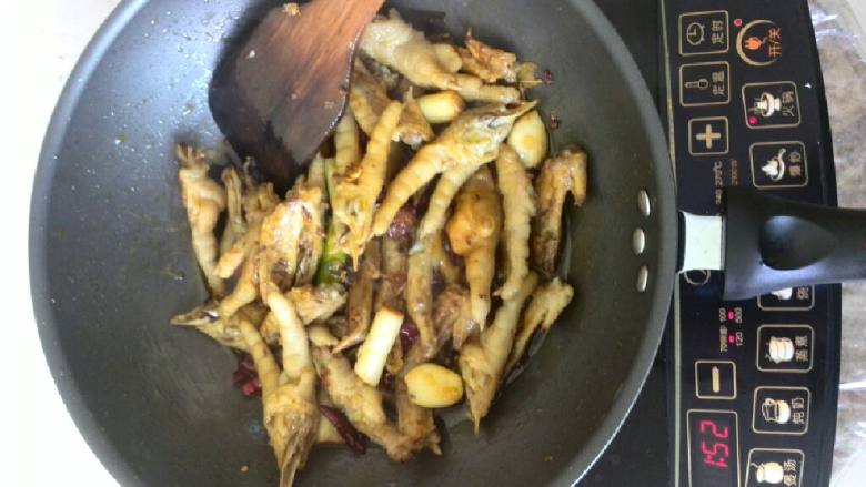 炒鸡尖鸡爪,翻炒7到8分钟时倒入酱油!(酱油的量是让所有的鸡尖和鸡爪能裹上色。)注意翻炒,不要糊锅。