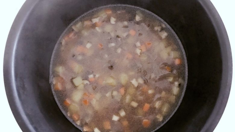 宝宝辅食:有饭、有菜、有肉,啥都有的土豆牛肉焖饭!18M+,把浸泡好的大米放入电饭锅,倒入步骤9的所有食材和汤料,并且翻拌均匀,按下电饭锅煮饭模式就可以了。