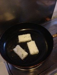 剩饭做米糕,锅中倒入适量油,七八成热时放入米胚。转中火