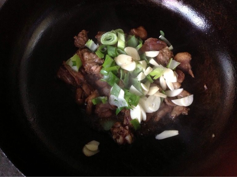 什锦海鲜饭,油热后,将鸭腿(鸡胸肉)炒至变色,放入蒜片、葱炒香。