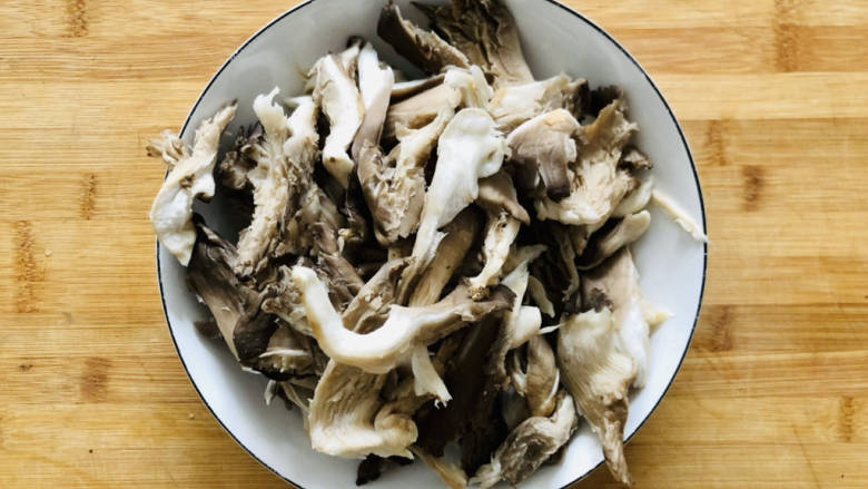 蘑菇炒肉片,蘑菇先用清水多冲洗几遍,然后撕成长条,用手攥干水分。