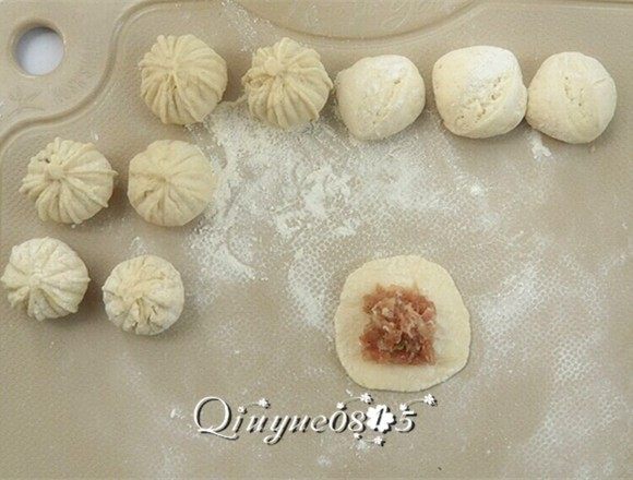 白萝卜包子#有个故事#,压扁擀开,把馅放入擀开的面皮上,包住馅,封口。