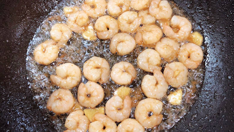 番茄海鲜饭,锅中倒入油,加热至五成热,放入虾仁,翻炒均匀。