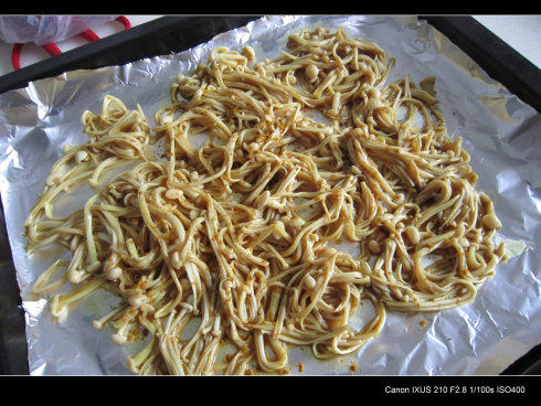 咖喱金针菇培根鸡蛋卷 ,烤盘铺锡纸,将拌好的金针菇均匀铺上,入烤箱中层,上下火180°15分钟