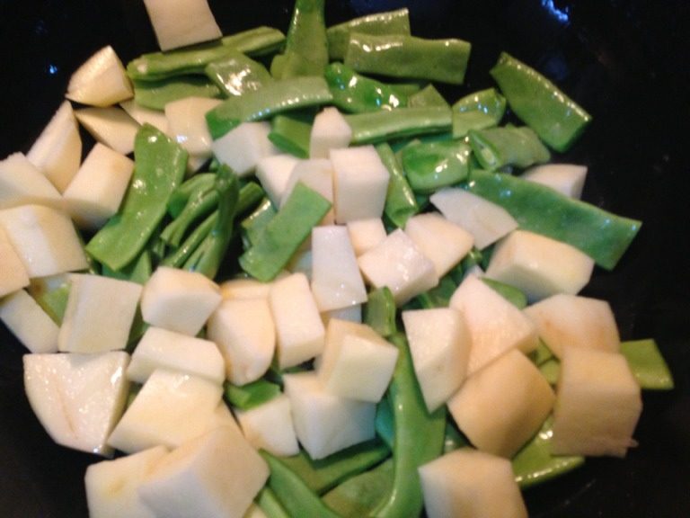 土豆焖豆角,放入土豆和豆角翻炒，炒至豆角断生，放入一半的蒜末炒出香味