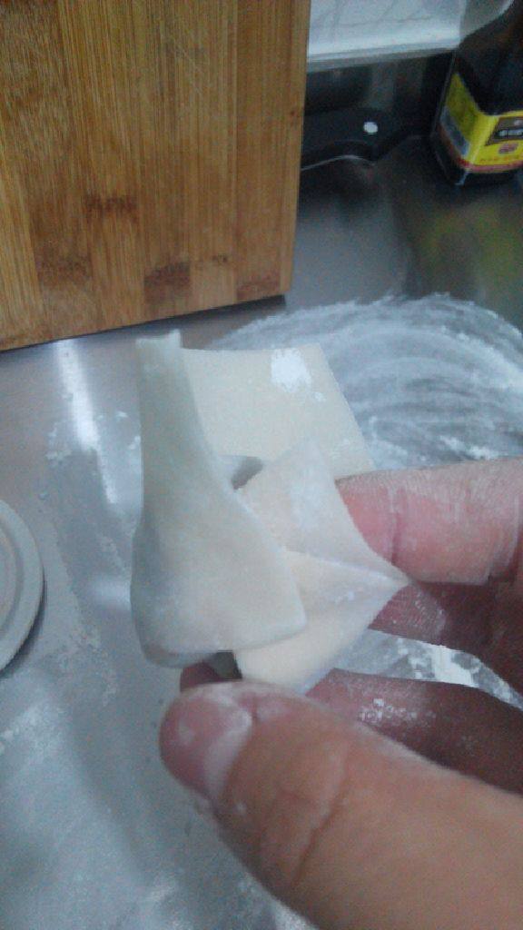 东北大馄炖,将卷肉馅的部分的两个角像这样粘在一起(买的皮要抹点水才能粘住)