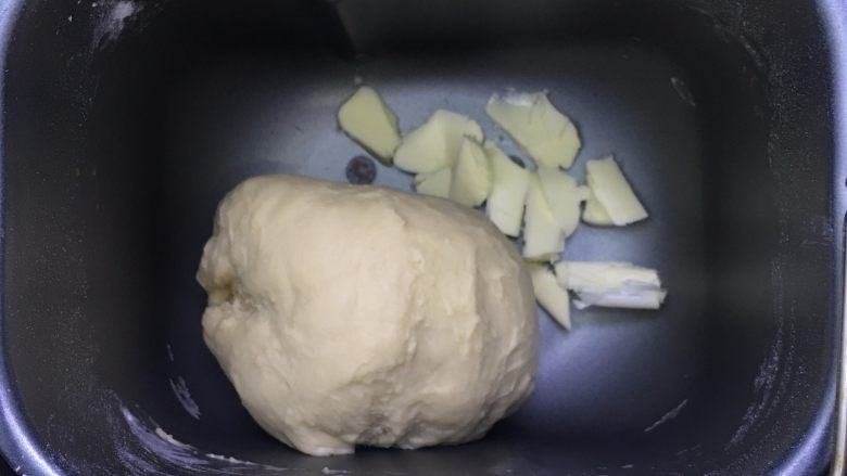 乳酪火腿面包,一个和面程序结束后,放入软化的黄油,再启动一个和面程序,此时已经达到扩展阶段。