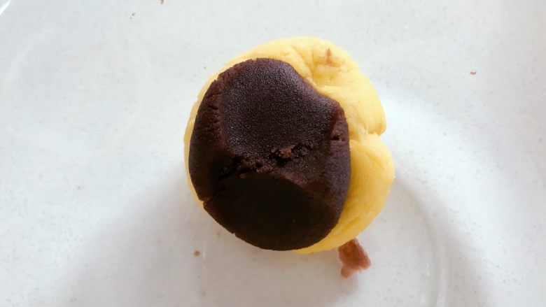宝宝辅食:南瓜豆沙包,然后用手将南瓜面团压成小圆饼状。需剩余一点南瓜面团,然后加点豆沙揉成深褐色面团。
》压的时候会有一点黏手,案板上撒点面粉,手上抹点面粉,不要太多,一点点就好。